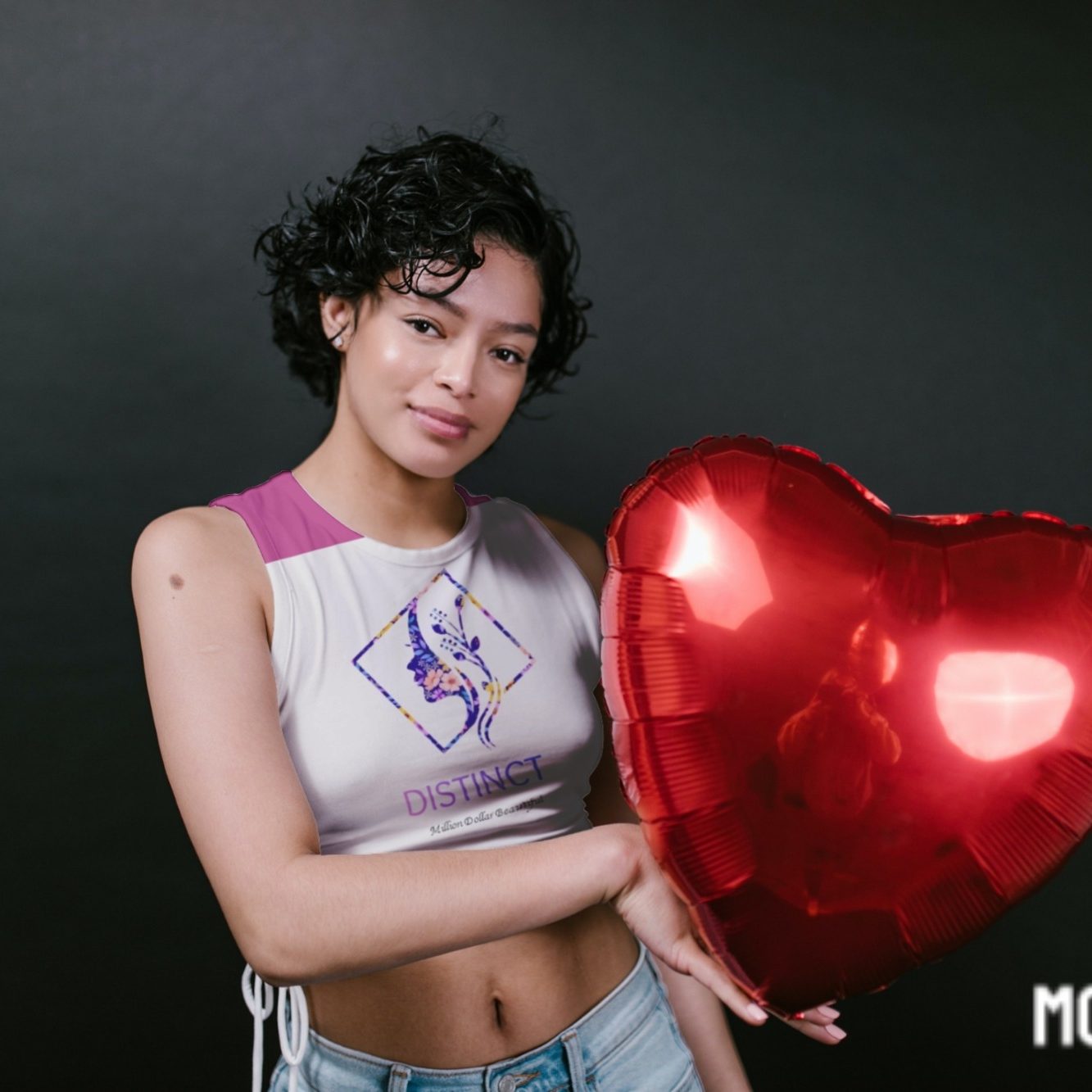 Person holding a large red heart-shaped balloon against a dark background.