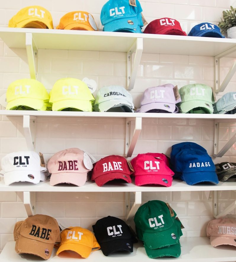 A display of colorful baseball caps arranged on shelves.